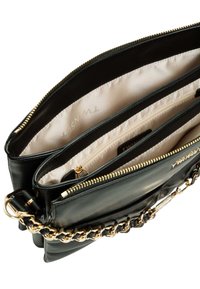 Borsa a mano in pelle nera con tracolla a catena dorata. L'interno presenta una fodera beige e diversi scomparti, tra cui una tasca con cerniera.