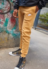 Nike Sportswear CLUB JGGR - Tracksuit bottoms - gold-coloured