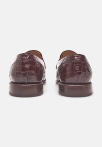 Braune Lederschuhe mit Krokodilstruktur, runden Zehen und einer stabilen Holzsohle. Die Rückansicht zeigt eine glatte Oberfläche und detaillierte Nähte.