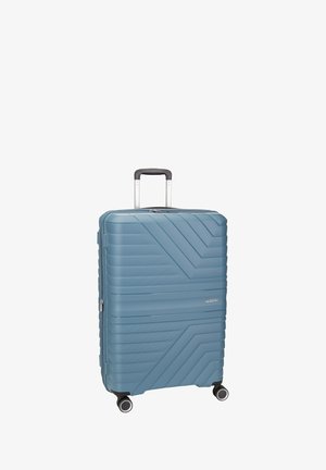 Valigia rigida di colore azzurro pastello, con texture a strisce verticali e diagonali, manico estraibile e quattro ruote girevoli.