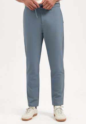 Lichtblauwe, taps toelopende broek van een zachte stof, met een broekband met trekkoord, zijzakken en een over het algemeen schone uitstraling.