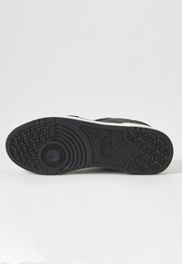 Talpa de adidasi negre cu un design din cauciuc texturat, având modele circulare și hexagonale. Accente albe de-a lungul marginii. Material rezistent.