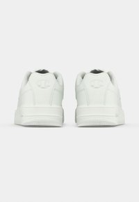 Λευκά αθλητικά παπούτσια με λείο δέρμα στην επάνω πλευρά, στρογγυλεμένη μύτη και επένδυση στο κολάρο. Διαθέτουν λογότυπο στη φτέρνα και ανάγλυφη ελαστική σόλα.