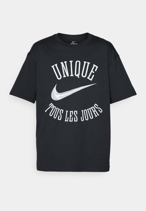 Crna pamučna majica s bijelim natpisom "UNIQUE TOUS LES JOURS" i srebrnim Nike logom. Klasičan dizajn s okruglim izrezom i kratkim rukavima.