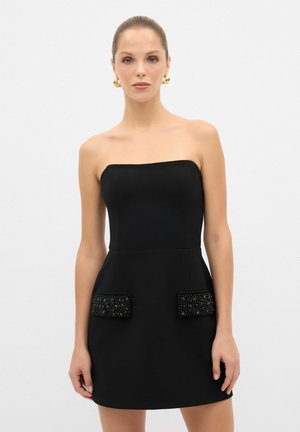 Zwarte strapless jurk met een getailleerde lijfje, uitlopende rok en decoratieve bewerkte zakken, met een gladde textuur in het geheel.