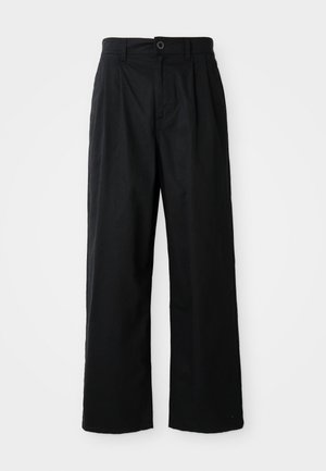 Zwarte, wijde broek van katoen met een gladde textuur, voorzien van een voorste knoopsluiting en twee zijzakken.