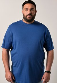 Camiseta de algodón suave de manga corta en azul royal, con un cuello redondo y un corte holgado para mayor comodidad. Sin patrones ni gráficos visibles.