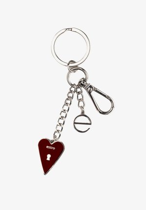 Sleutelhanger met een rode hartvormige bedel met een sleutelgat en de tekst "estro", bevestigd aan een zilveren ketting en een metalen clip.