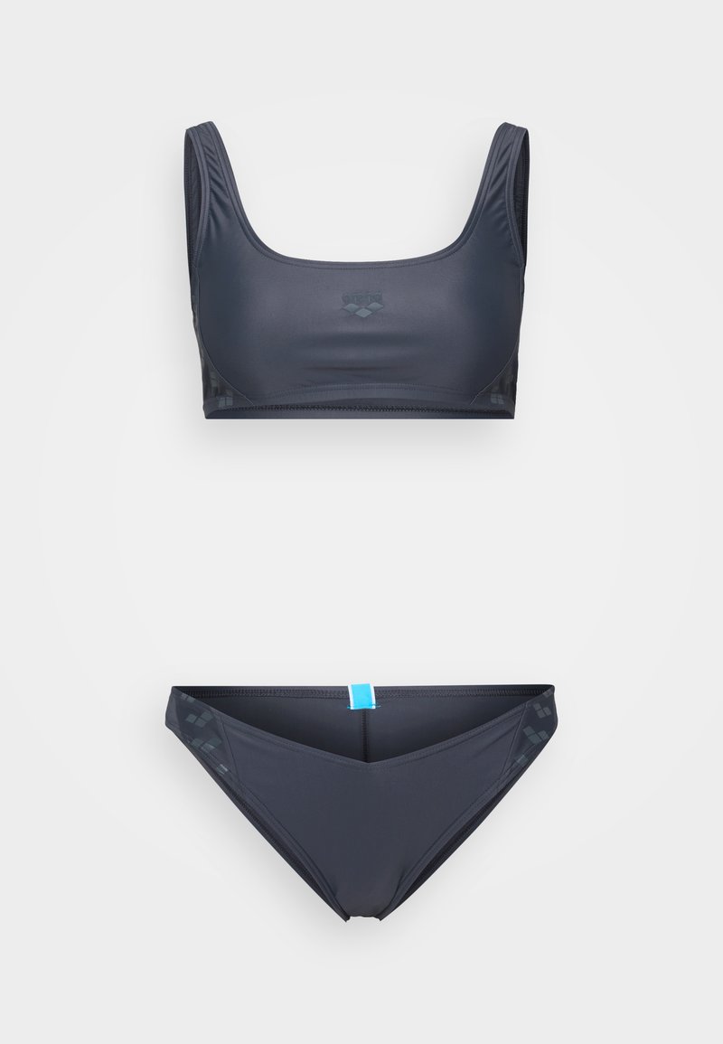 Dunkelblaues Bikini-Set bestehend aus einem sportlichen Bralette mit breiten Trägern und dezentem Logodetail, begleitet von passenden Bikiniunterteilen mit blauen Akzenten.