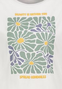 White t-shirt featuring a floral design in green, yellow, and purple with the text "BEAUTY IS WITHIN YOU" and "SPREAD KINDNESS."