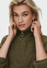 Pull en tricot vert foncé avec un col montant et des détails de fermeture éclair en argent. Texture douce, coupe décontractée, avec des poignets et un ourlet côtelés.