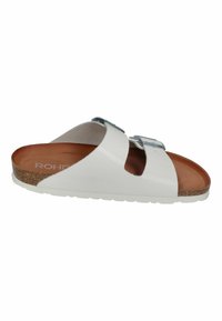 White sandal with two adjustable silver buckles, brown cork footbed, and textured white sole. Open-toe design, featuring smooth material.