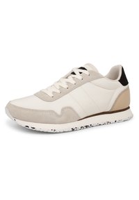 Bílé a béžové nízké tenisky s semišovými akcenty, šněrováním, polstrovaným límcem a tečkovanou bílou podrážkou na jednobarevném pozadí.