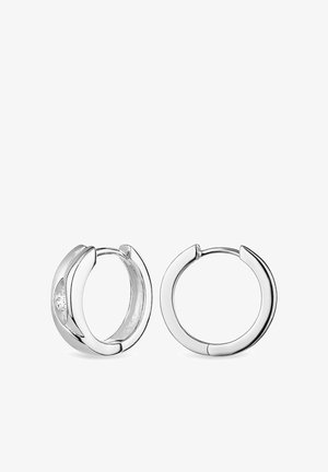 Boucles d'oreilles en argent avec une finition polie, présentant un design arrondi lisse et un petit détail en pierre claire encastrée.
