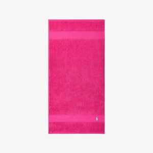 Roze katoenen badhanddoek met een effen textuur, twee horizontale strepen en een klein blauw logo rechtsonder.