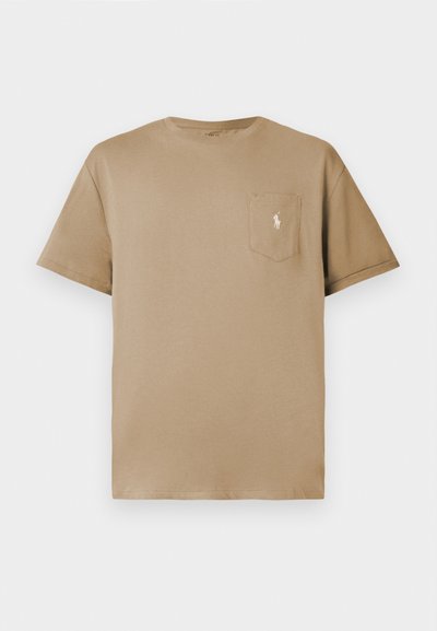 T-shirt en coton beige avec un col rond, des manches courtes et une poche sur la poitrine arborant un petit logo brodé. Texture douce, design décontracté.
