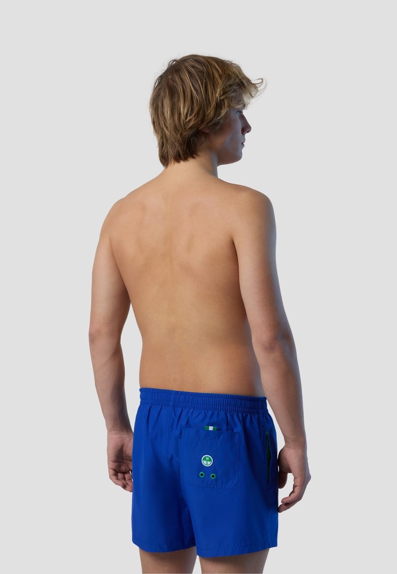 Pantaloni da bagno blu con vita elastica, due tasche laterali e una tasca posteriore con accenti circolari e fori di drenaggio.