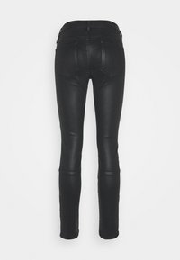 Jeans ajustados negros de denim, con una textura suave, diseño de cinco bolsillos y un ligero brillo, con una silueta ajustada.