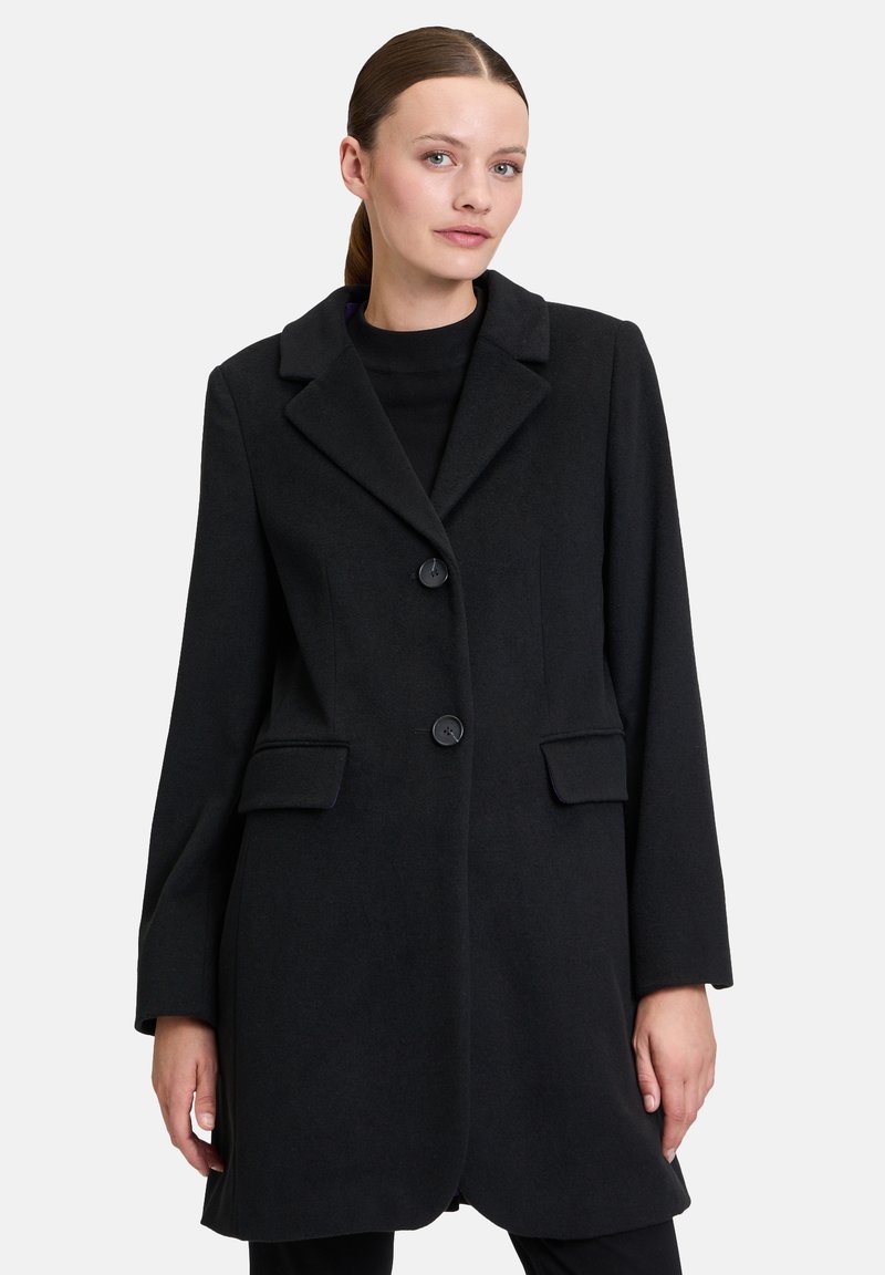 Schwarzer Wollmantel mit Reverskragen, zwei vorderen Taschen und zwei Knopfverschlüssen; zeichnet sich durch eine glatte Textur und eine maßgeschneiderte Passform aus.