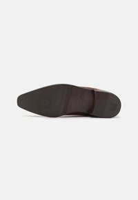 Suela de zapato de vestir de cuero marrón con puntera puntiaguda, texturizada con un emblema de logo, y un tacón de goma liso en contraste para mayor tracción.