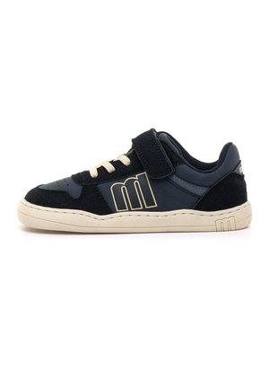 Zapatilla negra con suela beige, cordones beige y una tira de velcro, con un gran logotipo beige "M" en el lateral.