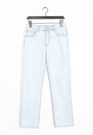 Jasnoniebieskie jeansy z denimu wiszące na czarnym wieszaku, z przednimi kieszeniami, szlufkami na pasek i zapięciem na guzik.