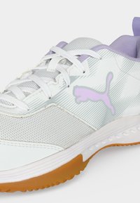 Λευκό και λεβαντίνι αθλητικό παπούτσι Puma με λευκά κορδόνια, επάνω μέρος από δίχτυ και εξωτερική σόλα από καουτσούκ, που δείχνει λεπτομέρειες από το πλάι και από μπροστά.