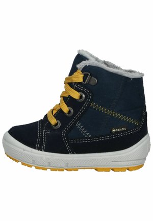 Navy-blaue Wildleder-Ankle-Boots mit gelben Schnüren, grauem Fleece-Futter und strukturierten weißen Sohlen. Mit kontrastierenden Nähten und einem Logo.