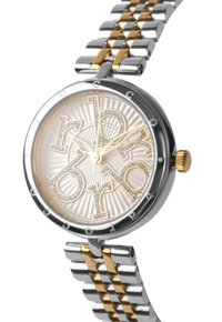 Reloj en tonos plata y dorado con una esfera redonda, dial texturizado de un dorado claro, letras en negrita y una pulsera de metal con eslabones alternos.