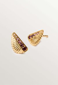 Pendientes de tono dorado diseñados en forma de media luna con una textura acanalada, presentando piedras preciosas moradas y claras dispuestas a lo largo del borde.