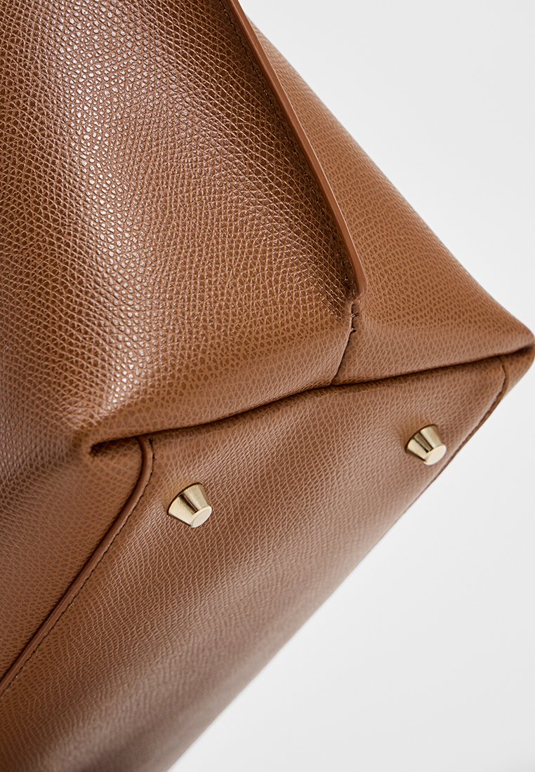 Brązowa, teksturowana skórzana torebka o trójkątnym kształcie, z złotymi akcentami na dolnej części i gładką krawędzią u góry.