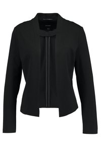 Musta bleiseri, tehty sileästä kankaasta. Siinä on piilotettu vetoketjusuljenta, avoin etuosa, pitkät hihat ja moderni kaulaton muotoilu.