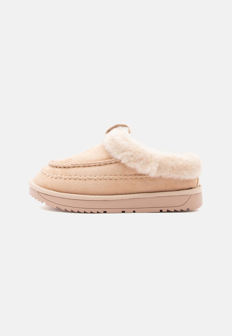 Suede slip-on slipper in light beige with a soft fur lining and stitching detail on the upper. Durable rubber sole with tread pattern.