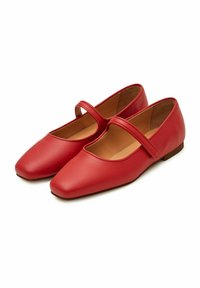 Bailarinas rojas de cuero tipo Mary Jane con punta cuadrada, una tira decorativa a lo largo del empeine y una suela baja y plana. Textura suave y minimalismo en el diseño.