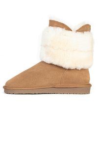 Tan mockask stövlett med en bred vit fuskpälskrage, rund tå och en texturerad gummisula för bra grepp. Ingen synlig hårdvara eller mönster.