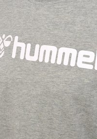 Lichtgrijze sweatshirt met een zachte textuur, voorzien van een groot wit "hummel" logo en een gestileerd bijontwerp aan de linkerkant.
