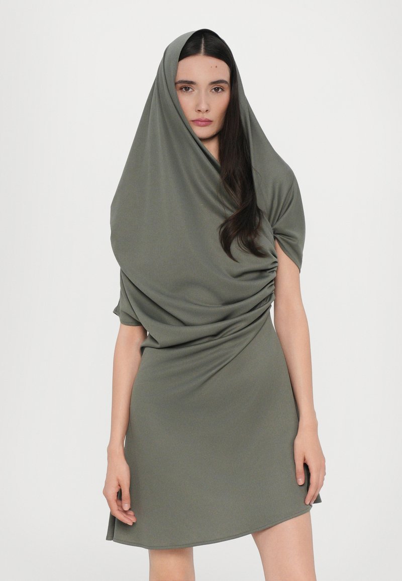 Olive green dress with draped fabric, short sleeves, and a hood. The fabric appears smooth and stretchy, featuring gathered detailing on the sides.