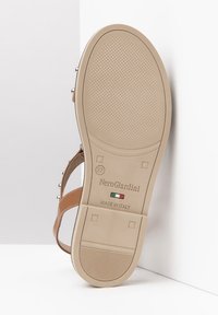 Sandalo beige con suola in gomma testurizzata, caratterizzato da un motivo a strisce, dettagli in metallo e fasce regolabili per una vestibilità ottimale. Taglia segnata 37.