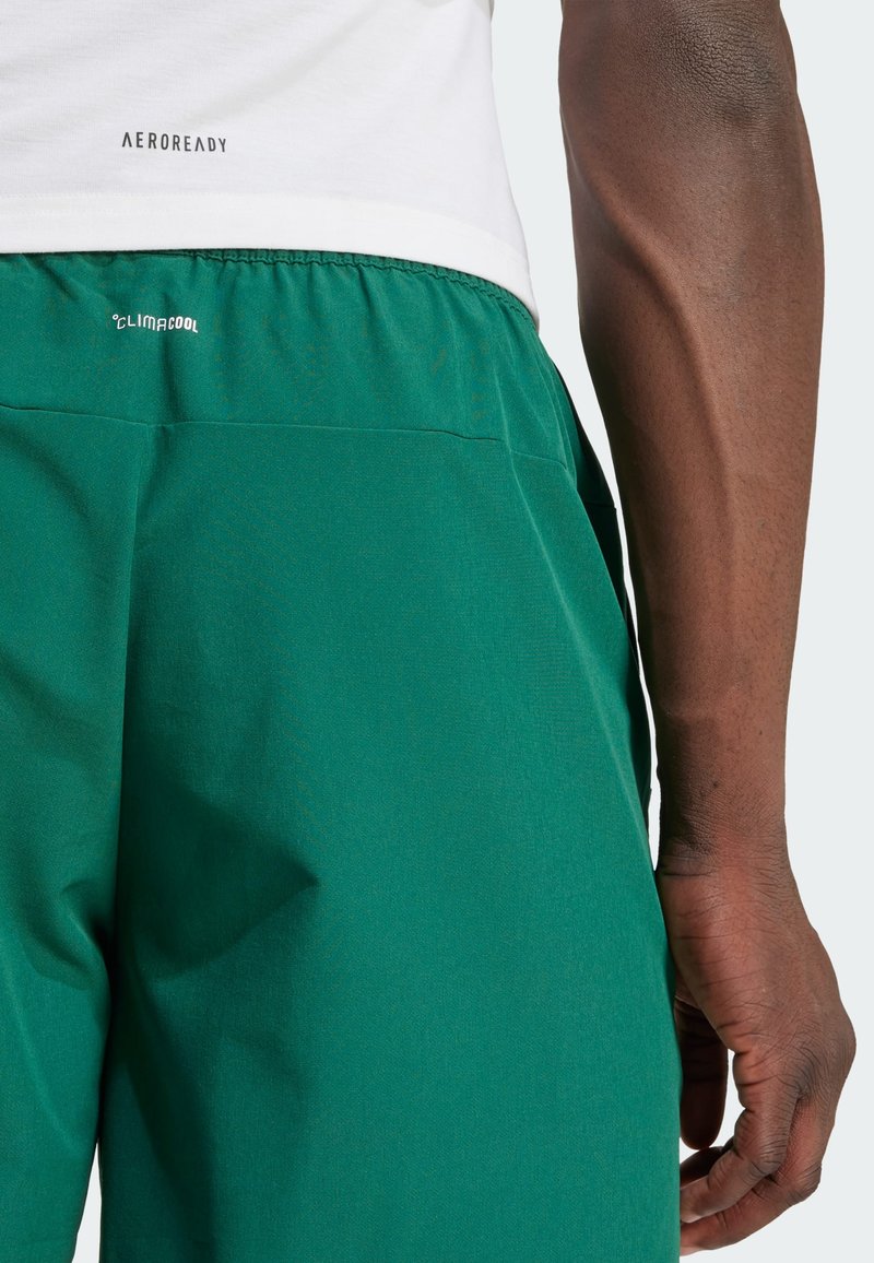 Pantalones cortos deportivos verdes con una tela texturizada, cinturilla elástica y bolsillos laterales. Logotipo ClimaCool en la parte posterior.