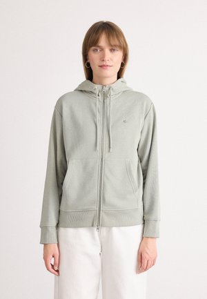 Light green zip-up hoodie made from soft fabric, featuring a hood, front pockets, ribbed cuffs, and a small logo detail.