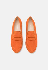 Orange suede slip-on shoes with a rounded toe and decorative front strap. Includes contrasting stitching and a rubber sole for traction.