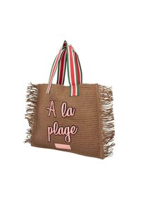 Geweven stro tas in bruin met roze letters "À la plage,"accentueert met groene en rode gestreepte handvatten en franjes.