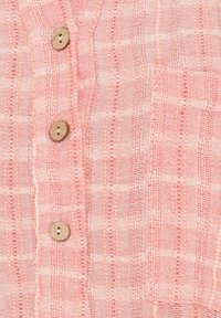Rosa tekstureret skjorte med lodrette striber og træknapper, med et lagdelt stofdetalje der skaber et subtilt, ternet mønster.