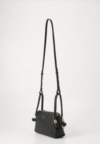 Sac à main en cuir noir, de forme rectangulaire, avec des accents en métal doré et une seule bandoulière ajustable ornée de détails noués.