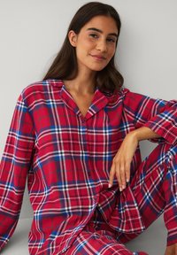 Rød og blå ternet flannel pyjamasæt med lange ærmer, knaplukning foran og blød tekstur, med en afslappet pasform og krave.