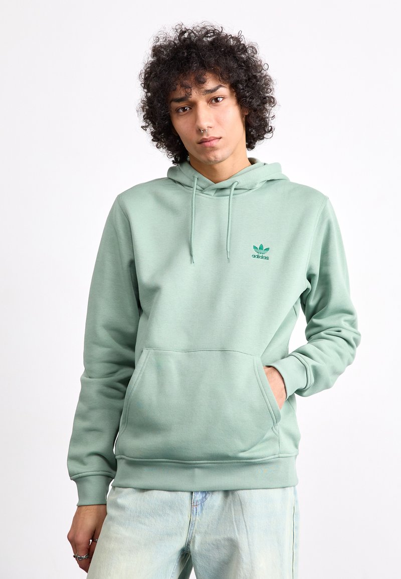 Mintgroene hoodie gemaakt van zachte stof, met een voorzijde kangoeroe-pocket en een verstelbare capuchon met trekkoord. Klein logo in contrasterend groen.