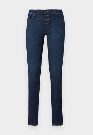 Jeans skinny in denim blu scuro. Chiusura con cinque bottoni e tasche frontali. Texture liscia, stile classico e silhouette aderente.