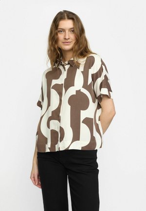 Short-sleeve, button-up shirt in cream with brown abstract pattern. Lightweight fabric with a relaxed fit and straight hem, paired with black pants.