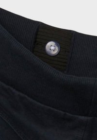 Mörkblå tygmidja med ribbad textur, prydd med en cirkulär, tunn, knapplikt. Slät material under midjan.