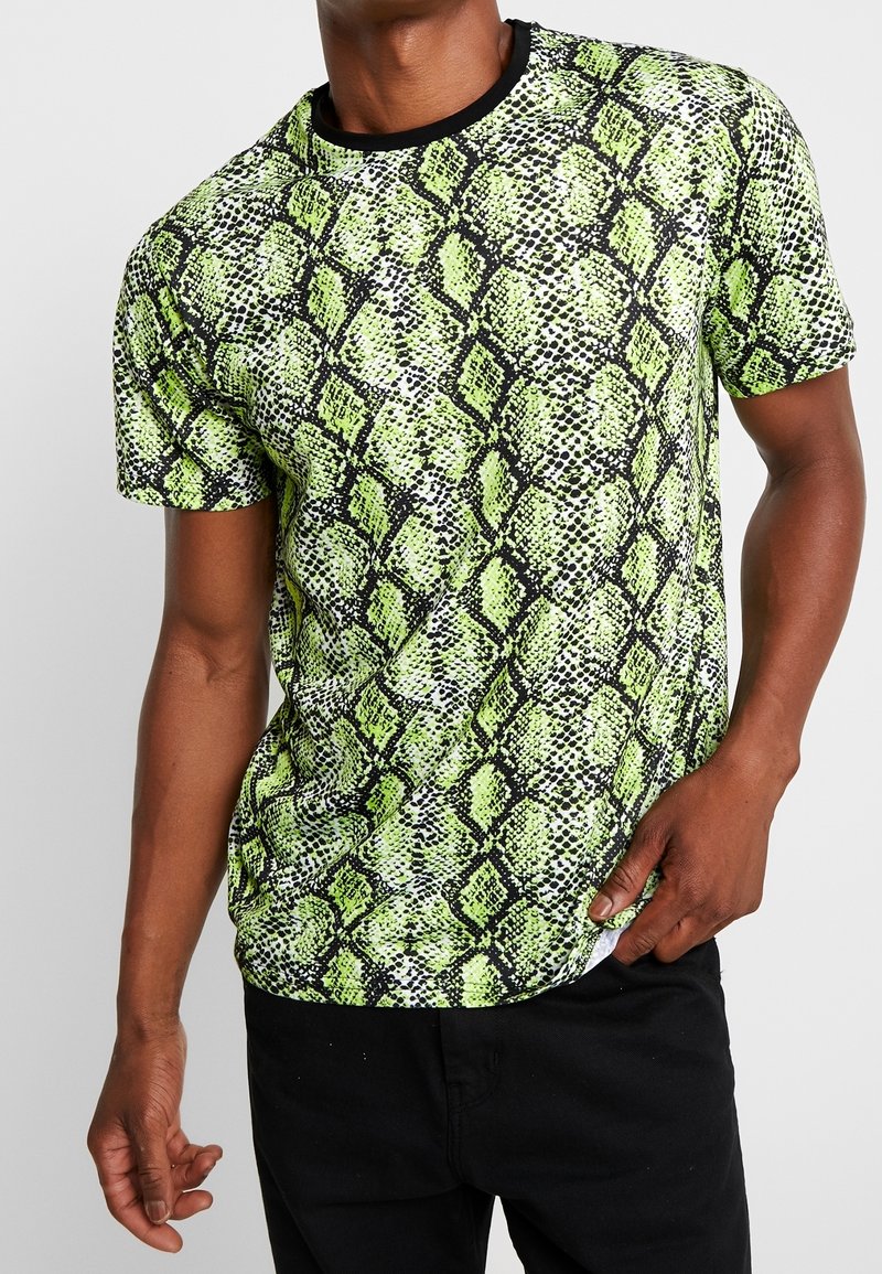 Kortærmet t-shirt med et mønster af grøn og sort slangeknæ, lavet af et glat stof med rund hals og sort kant.